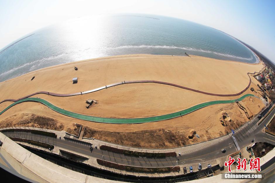 3月13日，秦皇島萬米臨海沙灘木棧道。據(jù)了解，該木棧道全長約4200米，與北戴河區(qū)原有的7500米木棧道對接后全線總長度1.17萬米，整個木棧道東起秦皇島體育基地游船碼頭，西至北戴河濕地公園，呈波浪形蜿蜒10.4公里海岸線。 中新社發(fā) 曹建雄 攝 CNSPHOTO